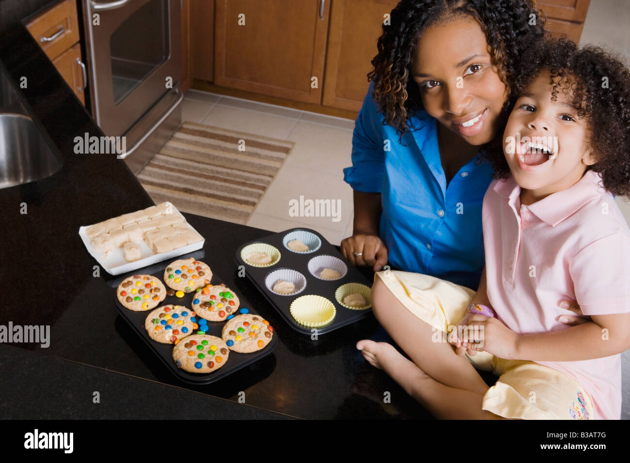 African mother and daughter making cupcakes Stock Photo