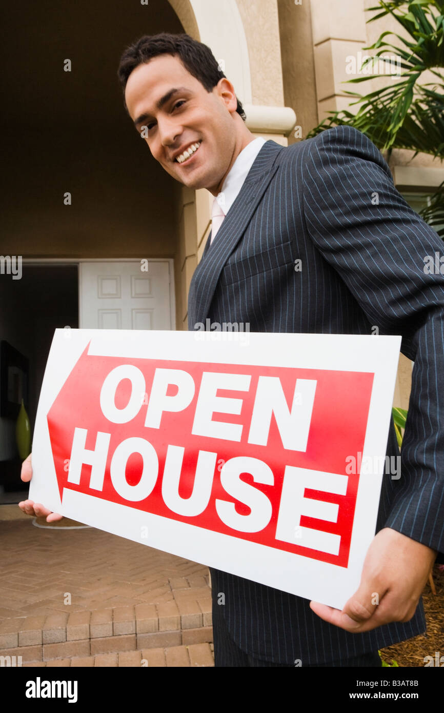 Hispanic real estate agent holding Open House sign Stock Photo - Alamy
