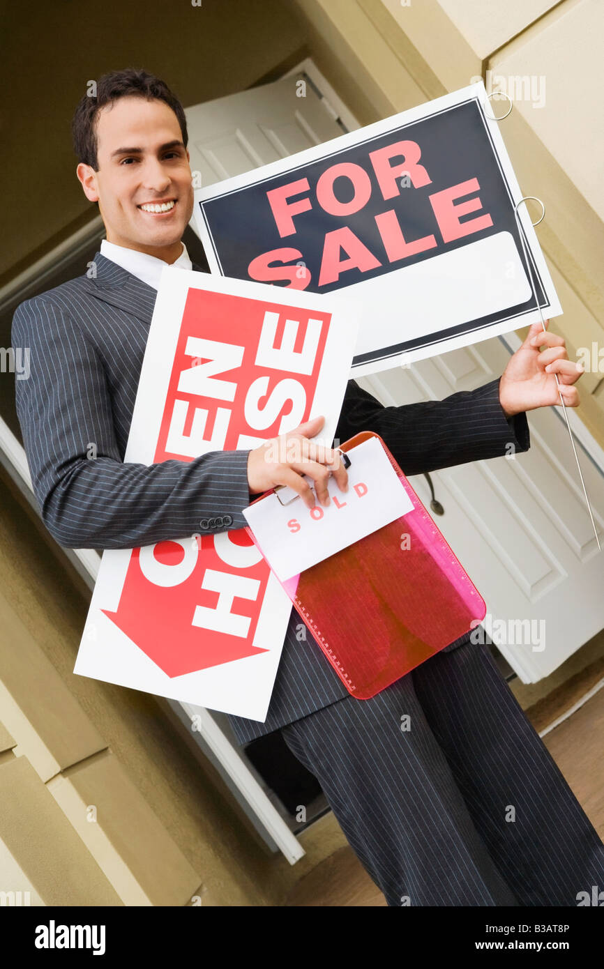 Hispanic real estate agent holding signs Stock Photo - Alamy