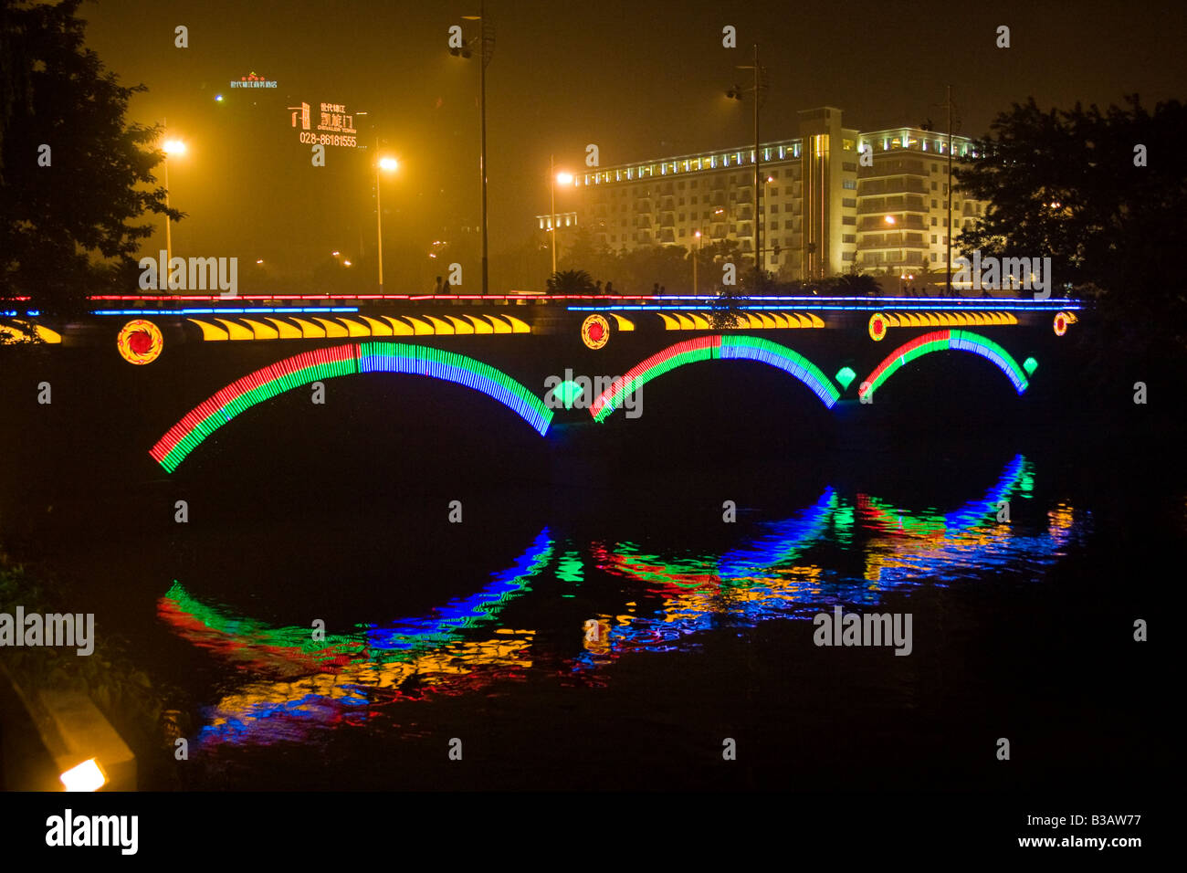 Jinjiang bridge over Jin River illuminated at night with Jinjiang Hotel in background Chengdu Sichuan Province China JMH3299 Stock Photo