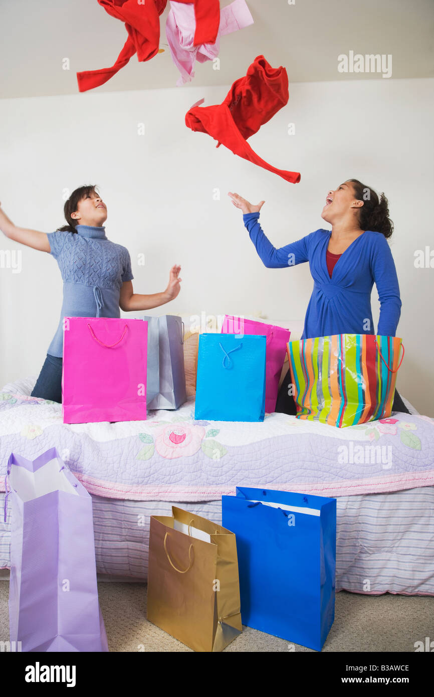 African twin sisters throwing clothing in air Stock Photo Alamy
