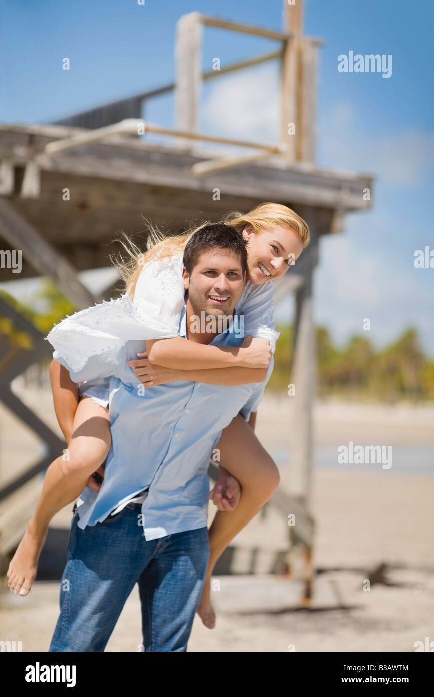 Man giving and adult woman a piggyback ride laughing and having fun in San  Diego, California. Stock Photo