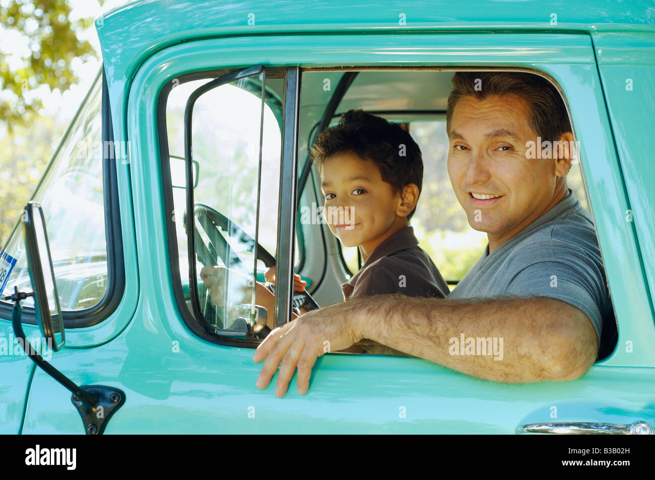 Hispanic father and son sitting in truck Stock Photo