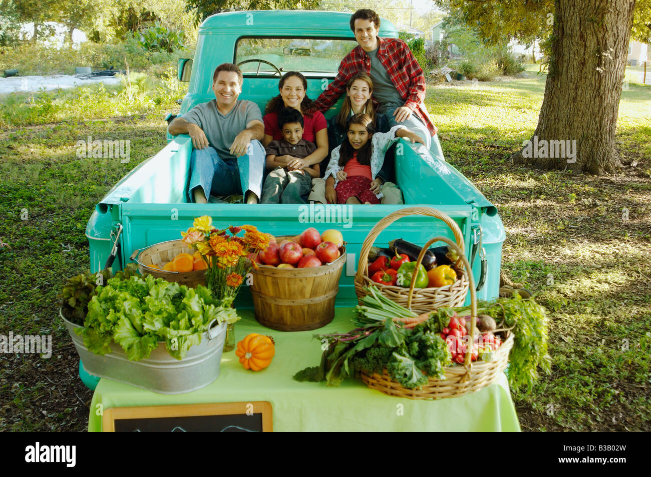 Multi-ethnic family in truck at farm stand Stock Photo
