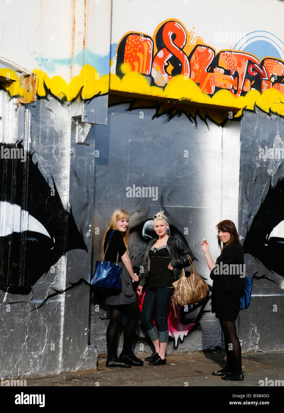 July 2008 - Women standing by a graffiti wall Liverpool England UK Stock Photo