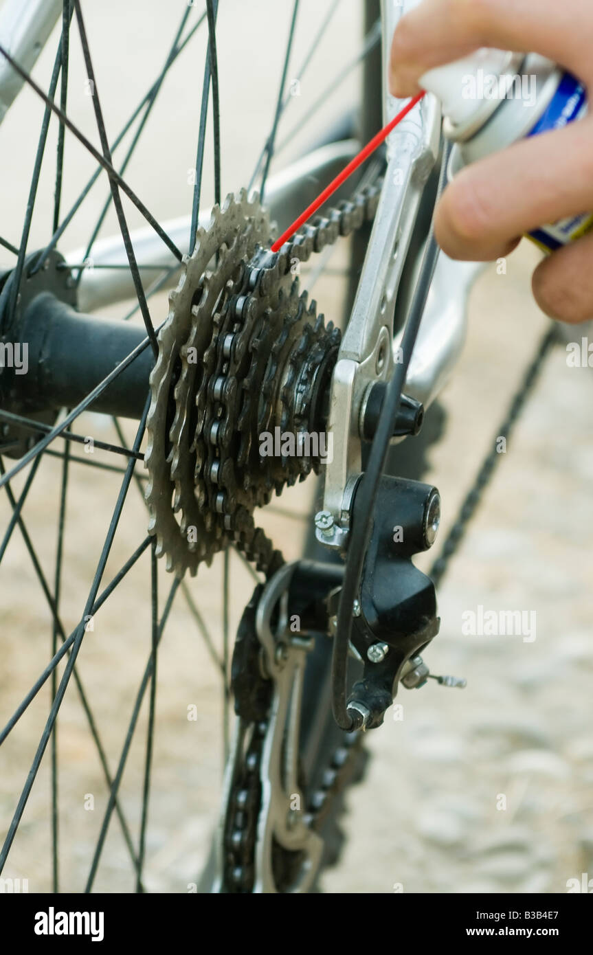 Lubrication of the chain of a mountain bike with a synthetic spray lube Stock Photo
