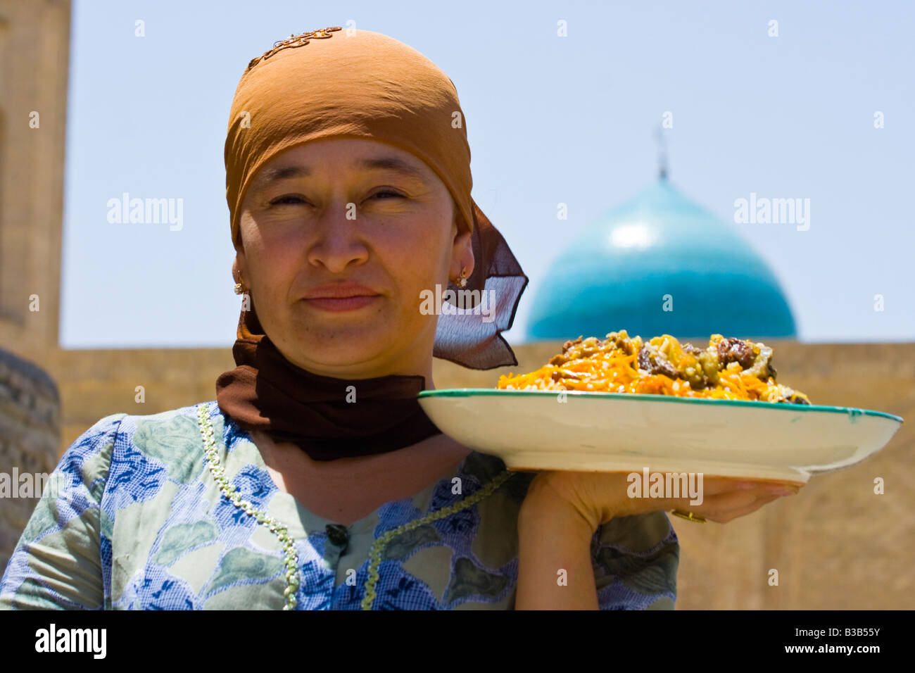 Woman with Plov in front of the Kalon Mosque in Bukhara Uzbekistan Stock Photo