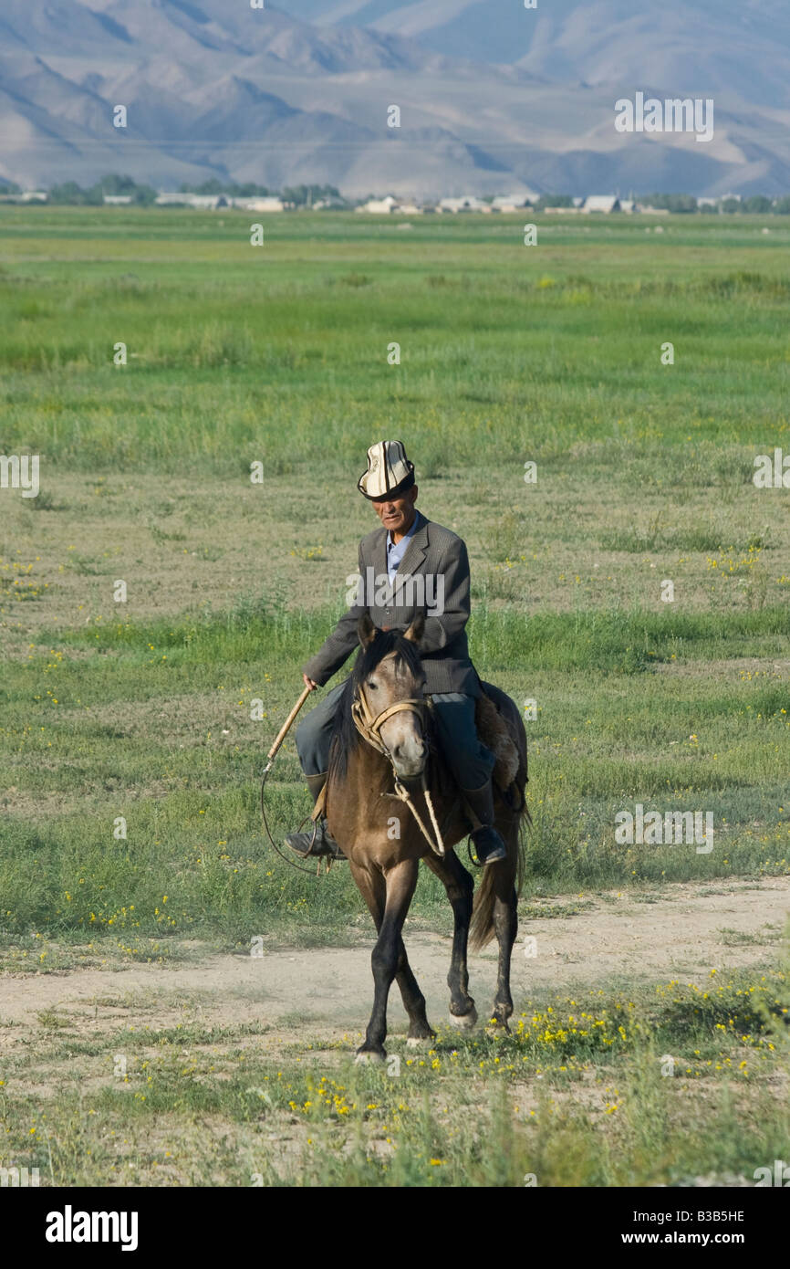 Kyrgyz Man on Horseback on the Road to the Torugart Pass in Kygryzstan Stock Photo