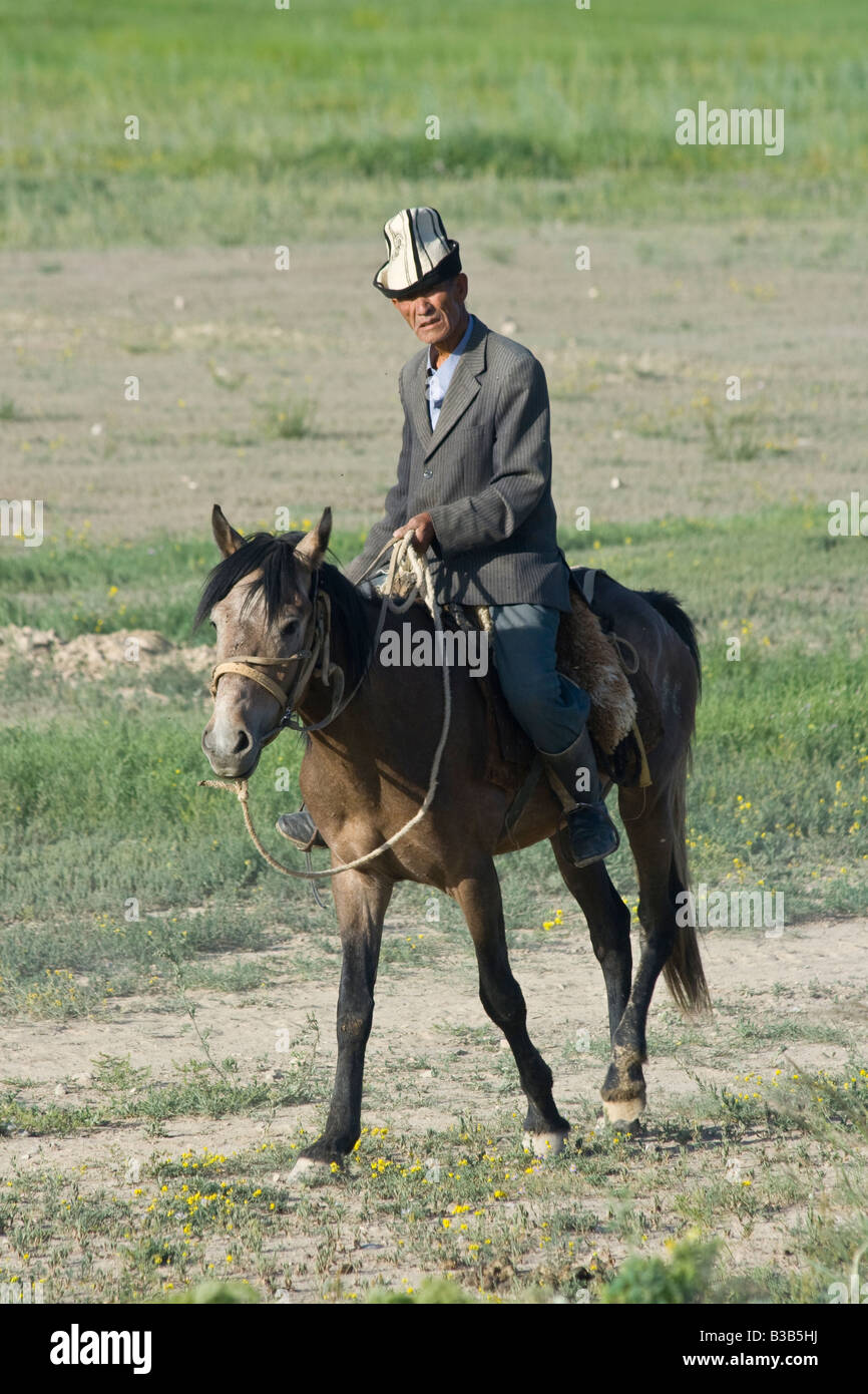 Kyrgyz Man on Horseback on the Road to the Torugart Pass in Kygryzstan Stock Photo