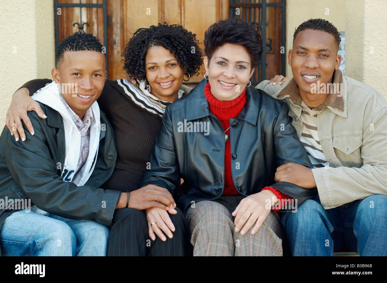 Mixed Race mother and adult children on porch steps Stock Photo