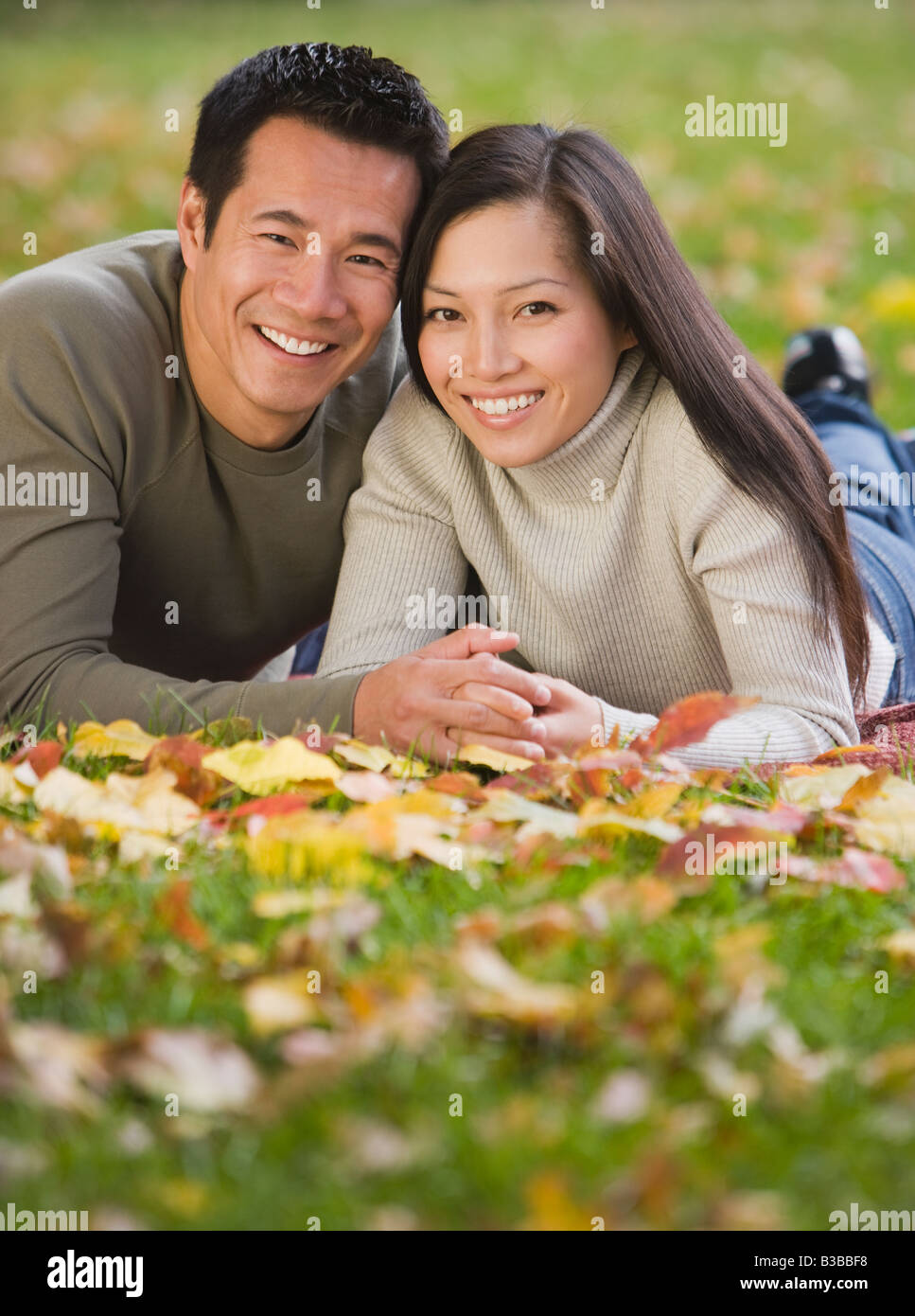 Asian couple laying in grass Stock Photo - Alamy