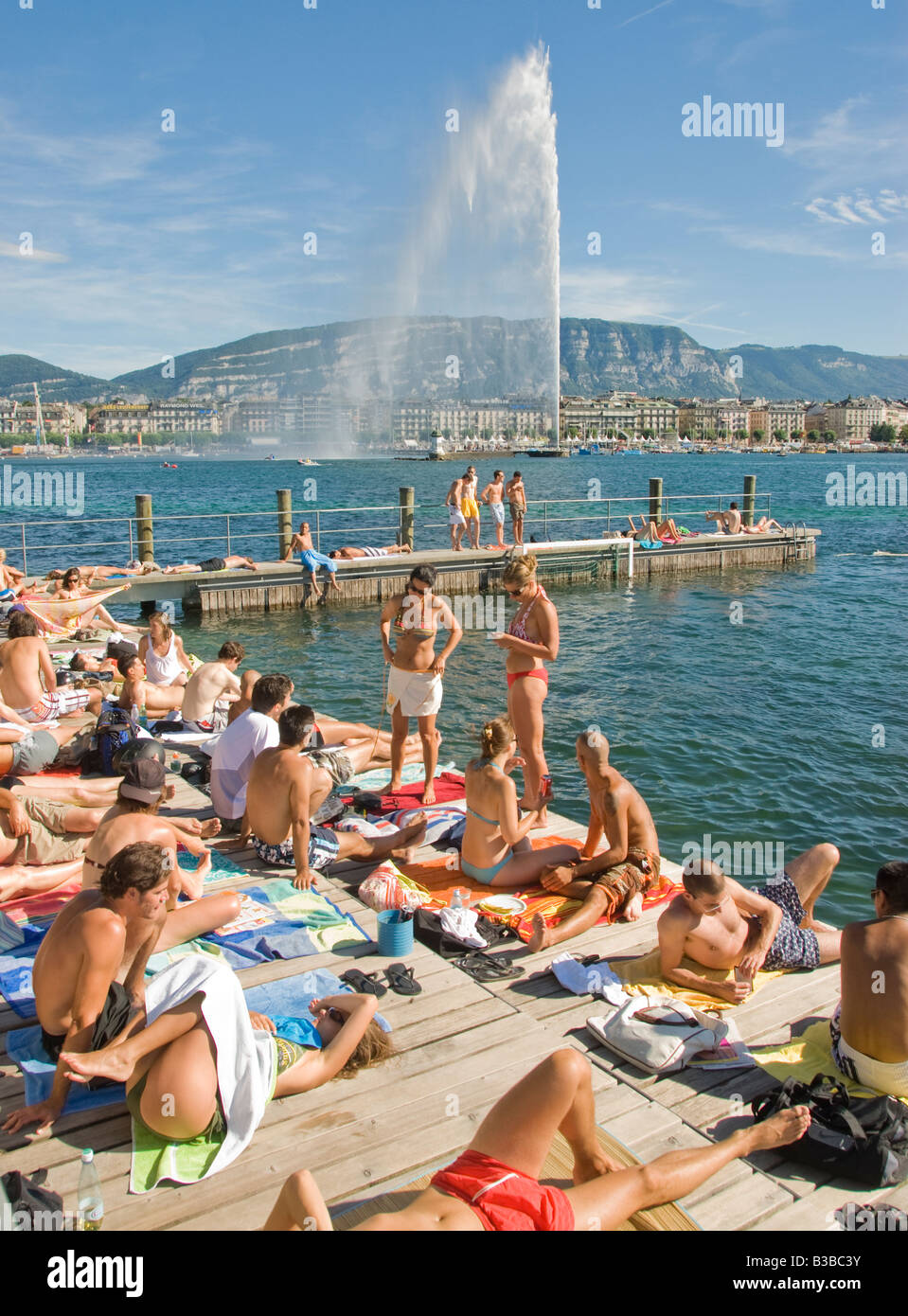 People relaxing at Bains des Paquis on Lake Geneva with Jet d Eau Stock Photo