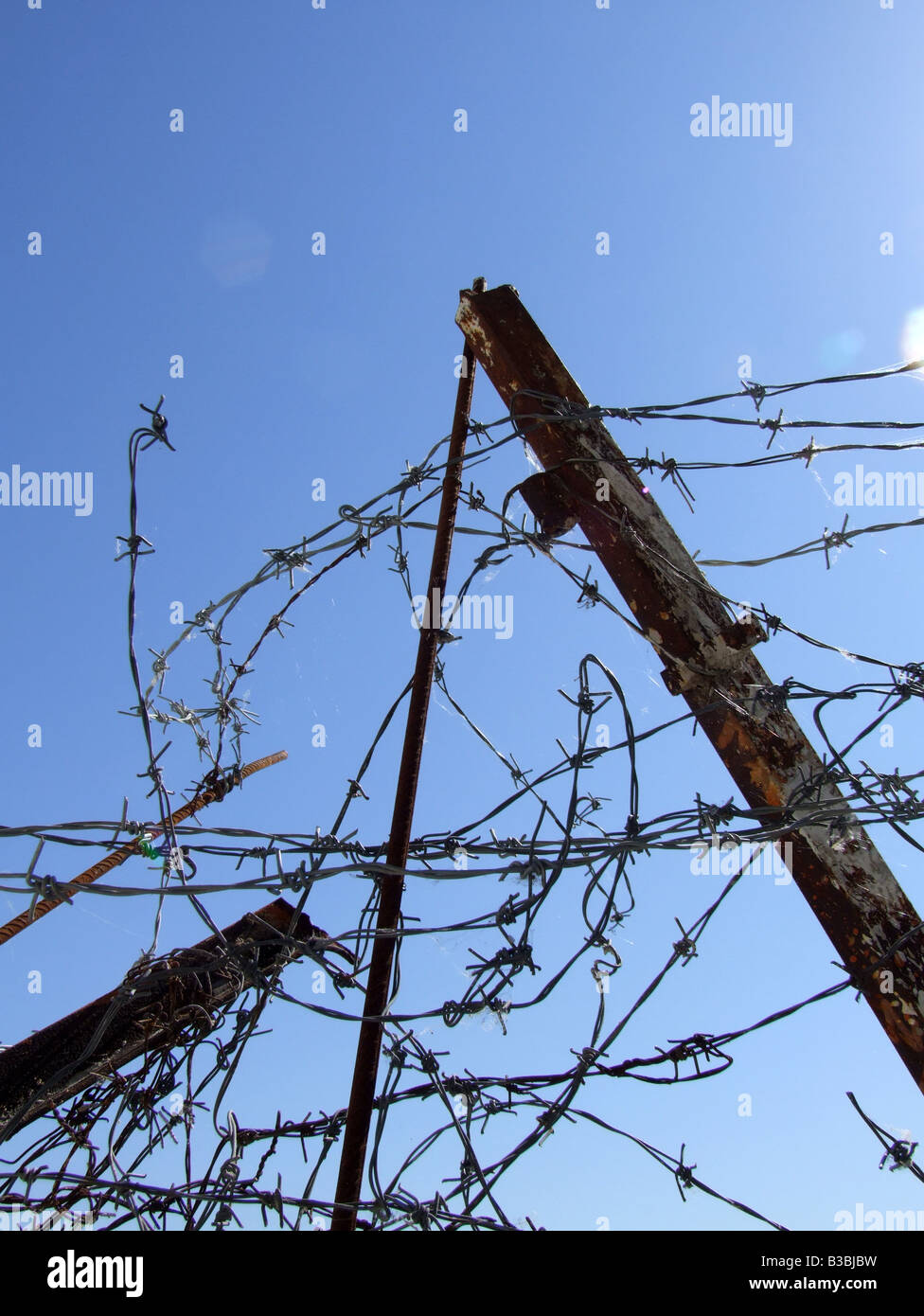 barbed wire fence with blue sky outdoors Stock Photo - Alamy