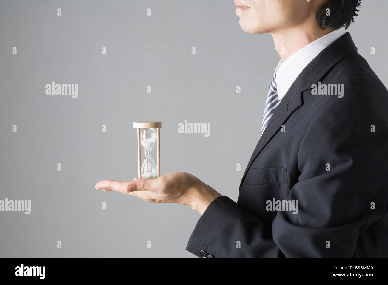 Businessman holding sand clock Stock Photo