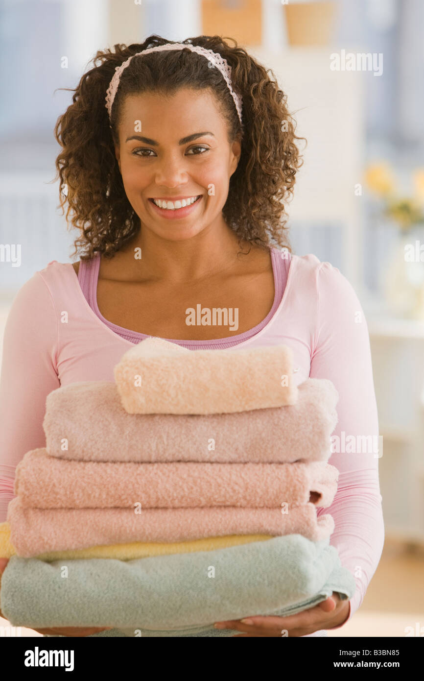 African woman carrying stack of towels Stock Photo - Alamy