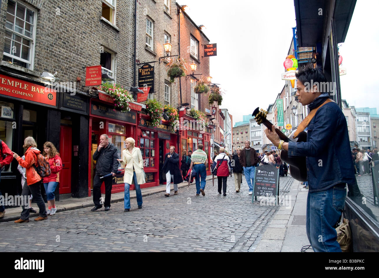 a busker plays guitar on the streets of Temple Bar Dublin Ireland Stock