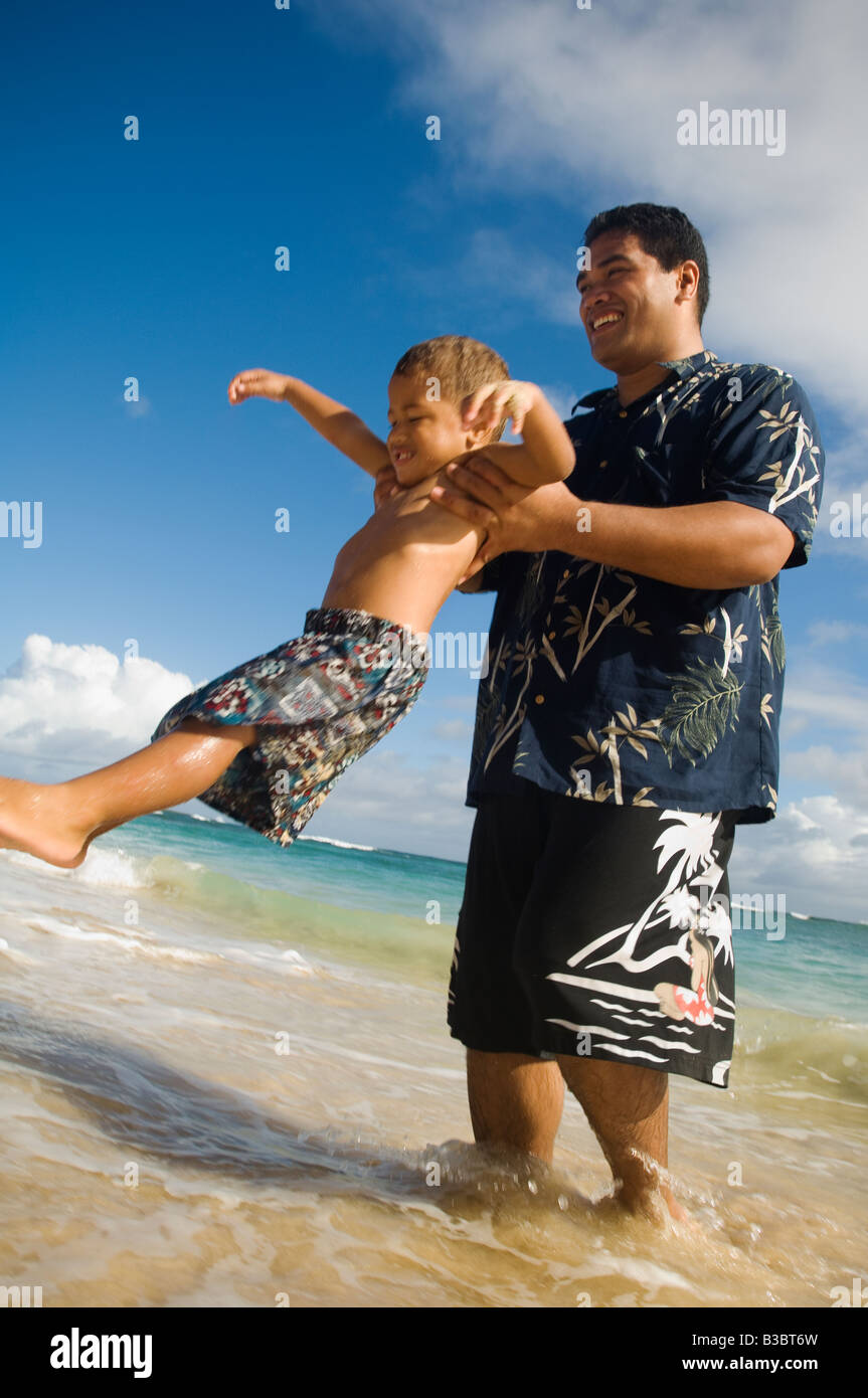 Pacific Islander father and son playing at beach Stock Photo
