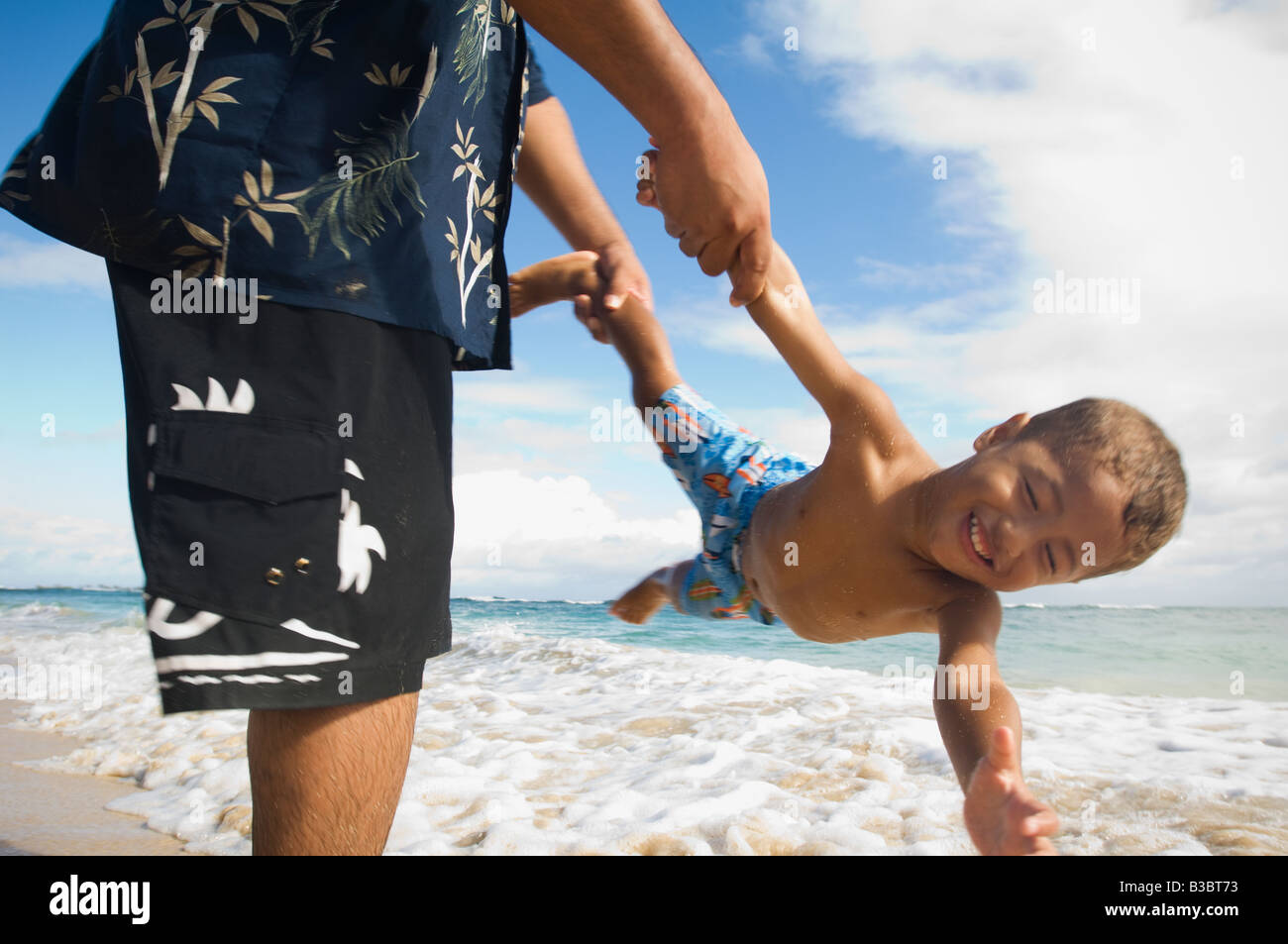Pacific Islander father and son playing at beach Stock Photo