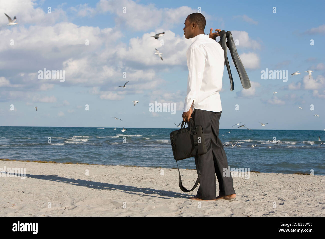 African businessman standing on beach Stock Photo