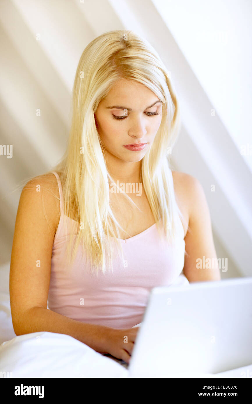 A young blonde woman using a laptop Stock Photo - Alamy