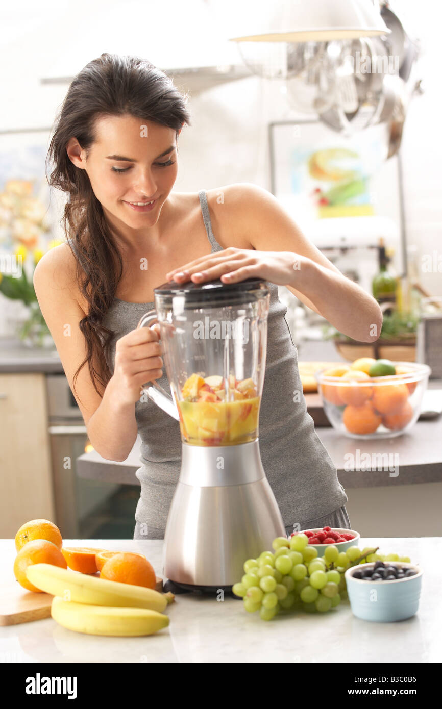 A young woman using a blender Stock Photo - Alamy