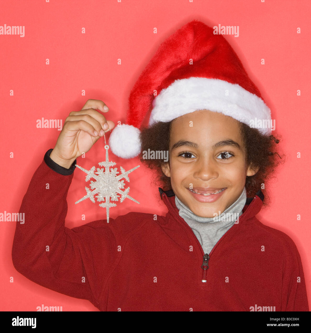Mixed Race boy holding Christmas ornament Stock Photo Alamy