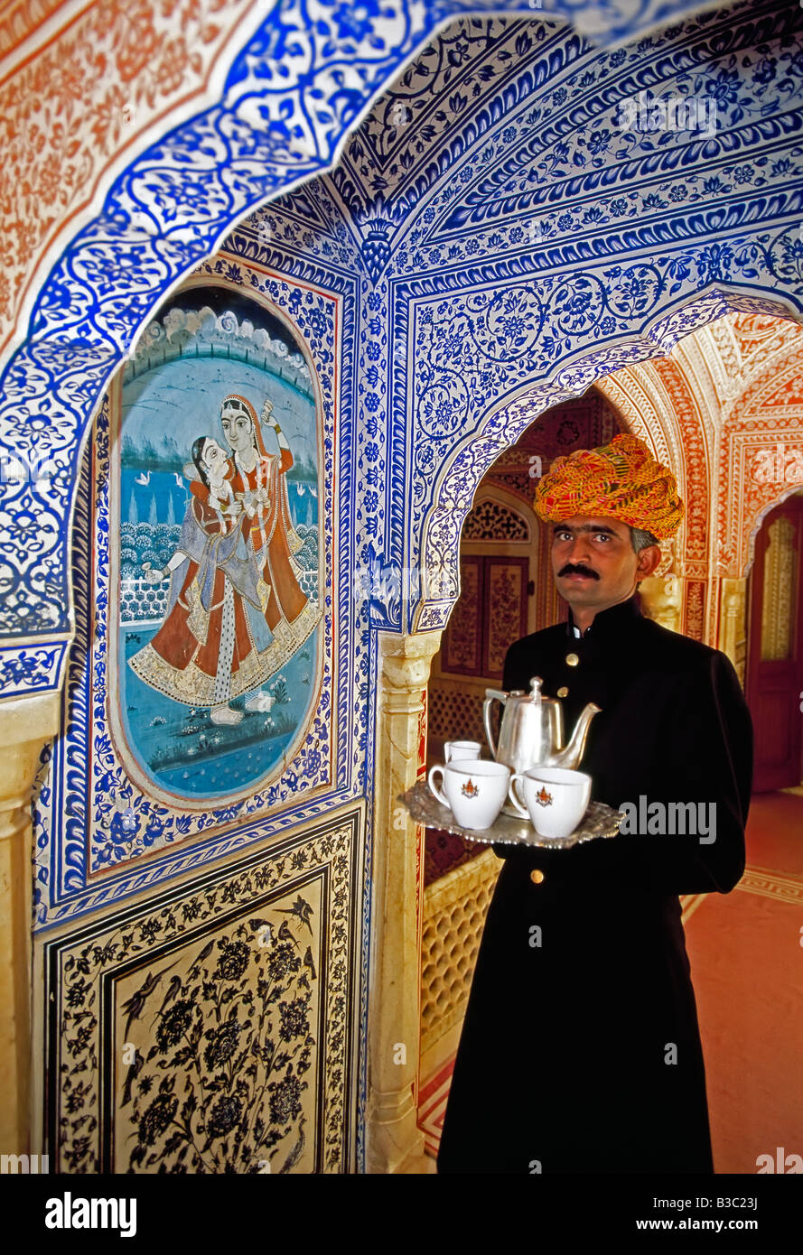India, Rajasthan, Jaipur, Samode Palace, Waiter holding Tea Tray in ornate passageway -  Model and Property released Stock Photo