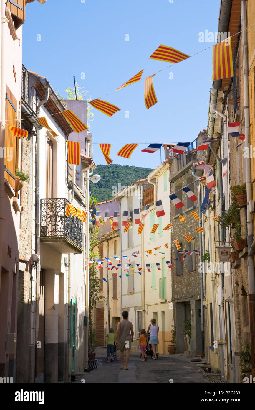 A street is decorated with flags and streamers in both Catalonian and French colours for the French national holiday Stock Photo