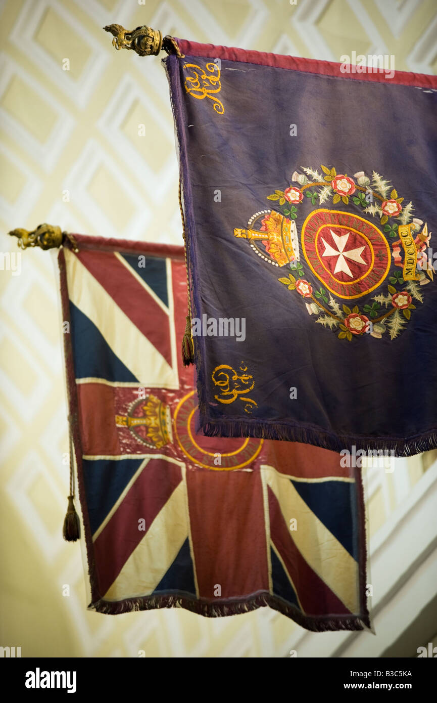Malta, Valletta. The colours of Maltese forces in the style of British Regiments showing the Maltese Cross, hang in the St John's Co-Cathedral in the centre of the walled city of Valletta. Stock Photo