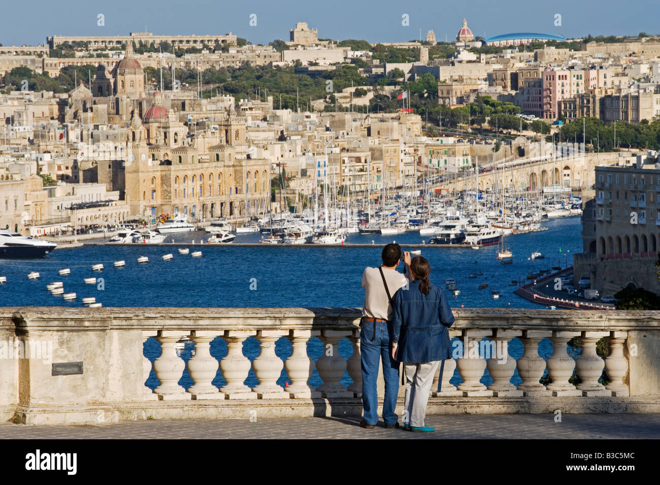 Malta, Valletta. Tourists look out from an elegant ballustrade on the