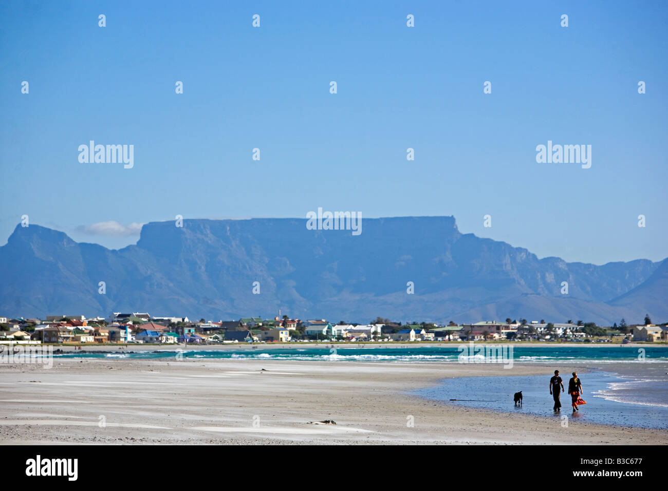 South Africa, Western Cape, Cape Town.  Looking across Table Bay to Table Mountian from Bloubergstrand on a Sunday with walkers Stock Photo