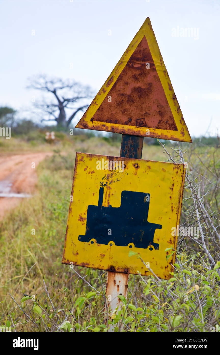 Kenya, Tsavo. Old railway crossing sign near the approach to Tsavo Railway Station. Tsavo was the place where two man-eating lions devoured twenty-eight Indian coolies and many African workers in 1898, holding up construction of a bridge on the Uganda Railway for several months. Stock Photo