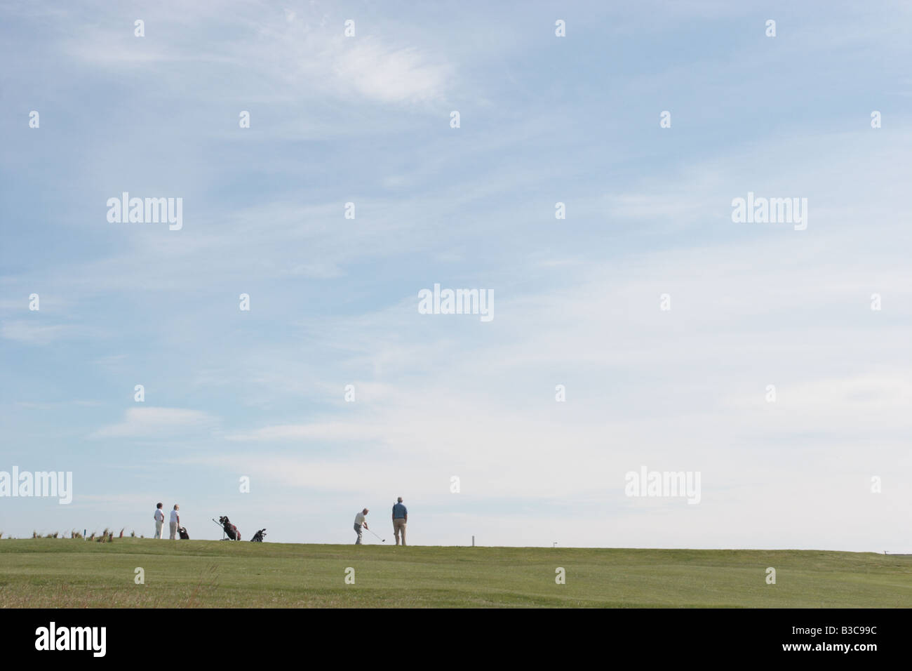 Mixed party of male and female golfers sihouetted against the sky in the East Neuk of Fife near St Andrews, Scotland. Stock Photo