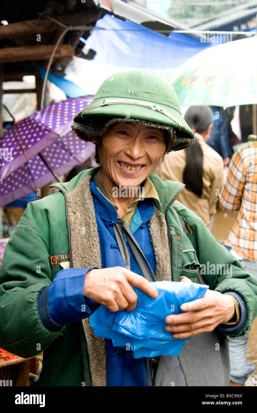 A portrait of a happy market trader wearing a Vietnamese army hat in a market Vietnam Stock Photo