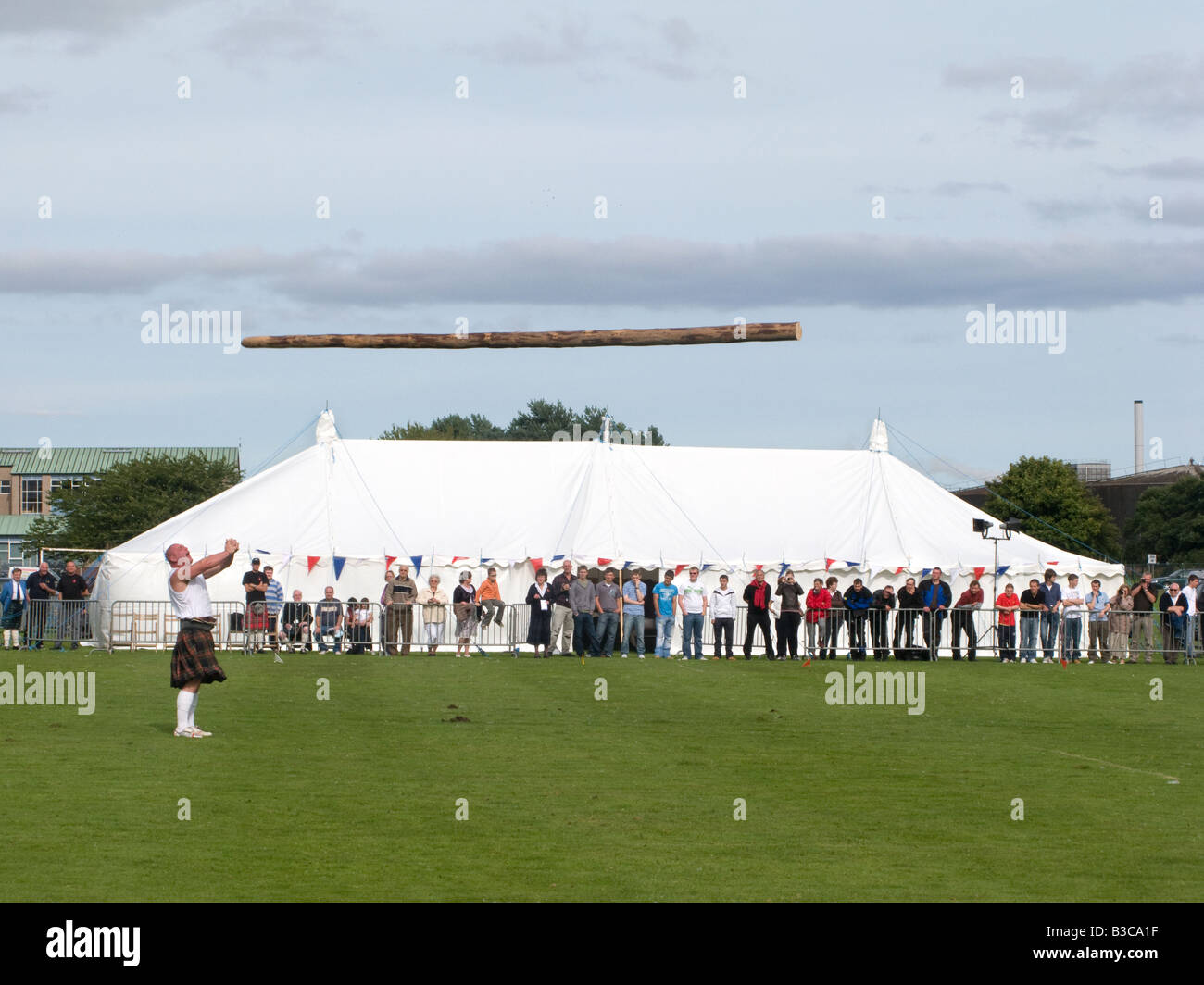 A contestant tosses the caber (the trunk of a pine tree) at a Scottish Highland Games gathering in Invergordon, Scotland Stock Photo