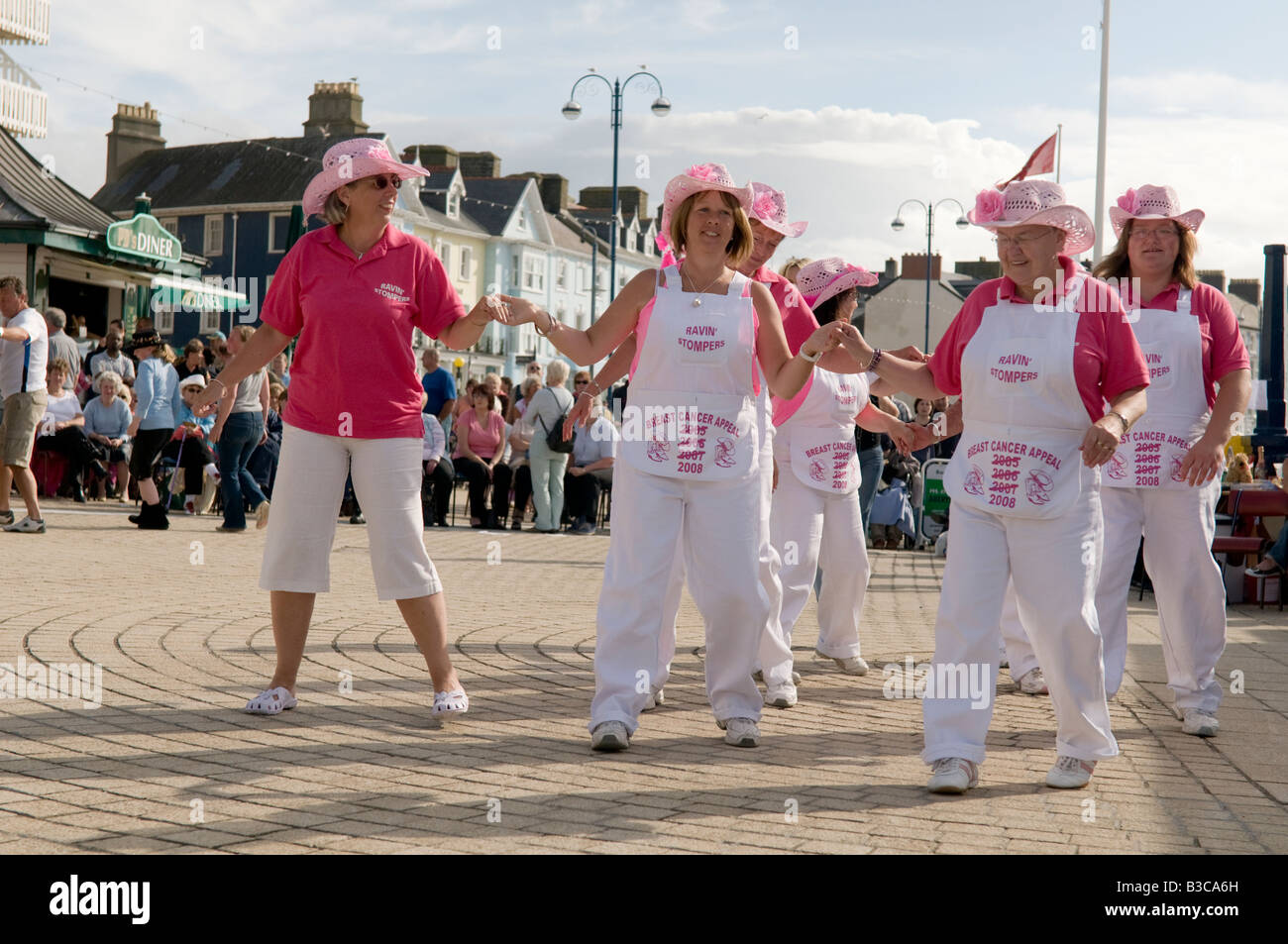 Group of women charity fund raising Line dancing in aid of cancer Research on Aberystwyth Promenade summer afternoon Wales UK Stock Photo