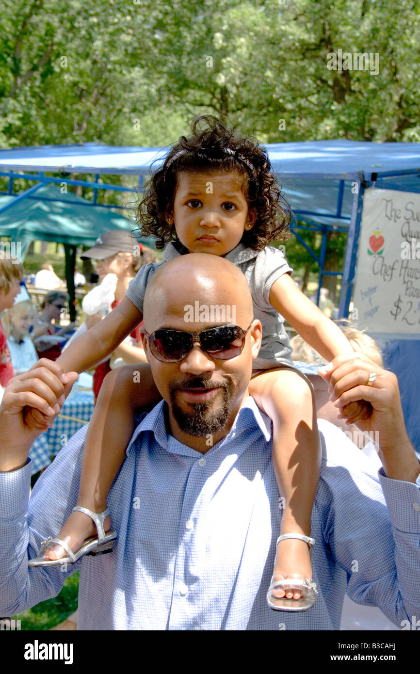 Man with daughter on shoulder enjoy celebration. Svenskarnas Dag