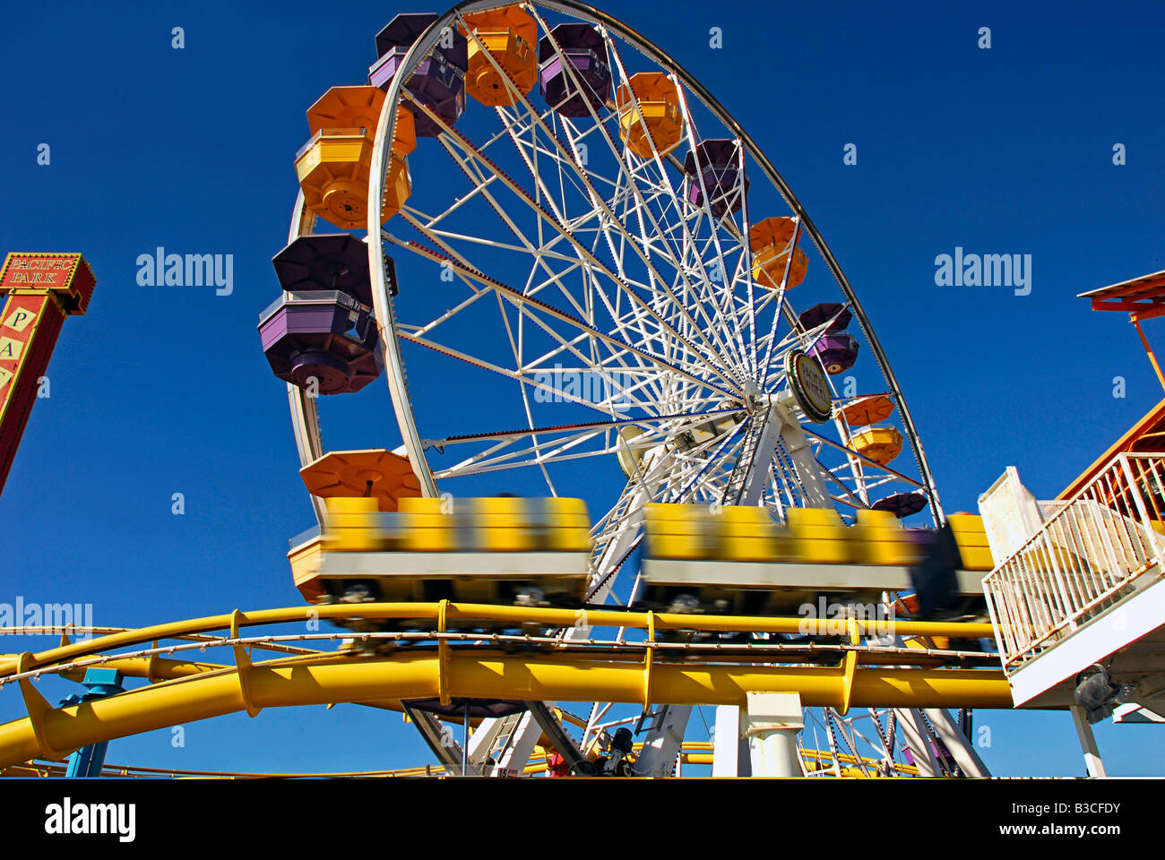 Pacific Park, Santa Monica CA pier family amusement park large Ferris wheel Roller Coaster moving ovber the ocean Stock Photo