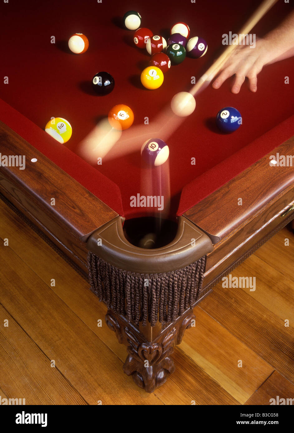 Tight shot of pool table with only the player's hand visible, holding