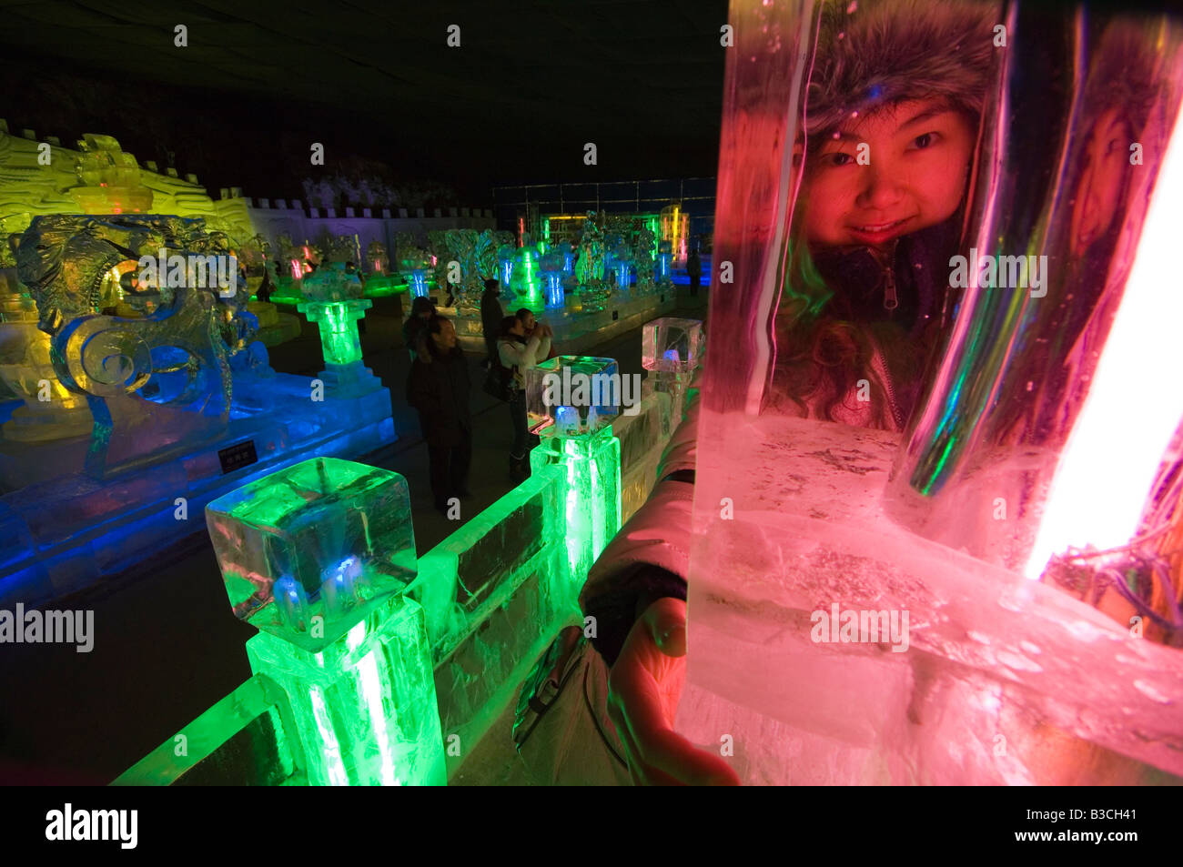 China, Beijing, Longqing Gorge Tourist Park. Ice sculpture festival - a girl's face looking through an ice sculpture Stock Photo