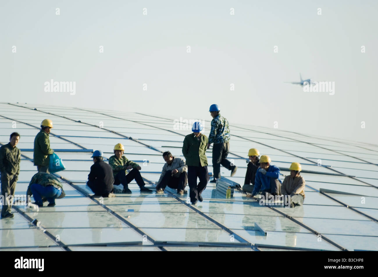 China, Beijing, Beijing Capital Airport. Workers on top of the new Terminal 3 building opened February 2008 Stock Photo