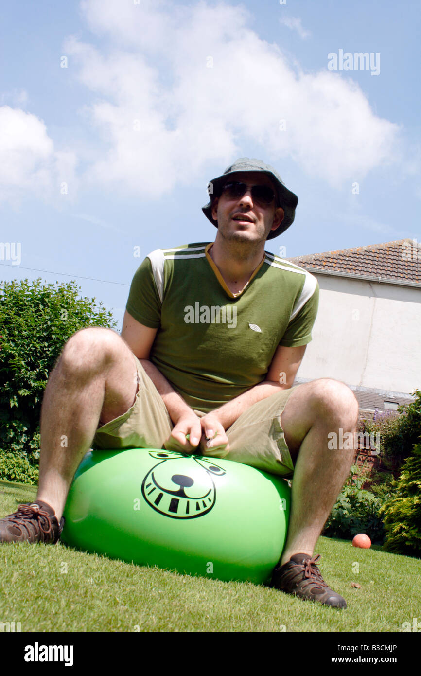 Man bouncing on a space hopper Stock Photo