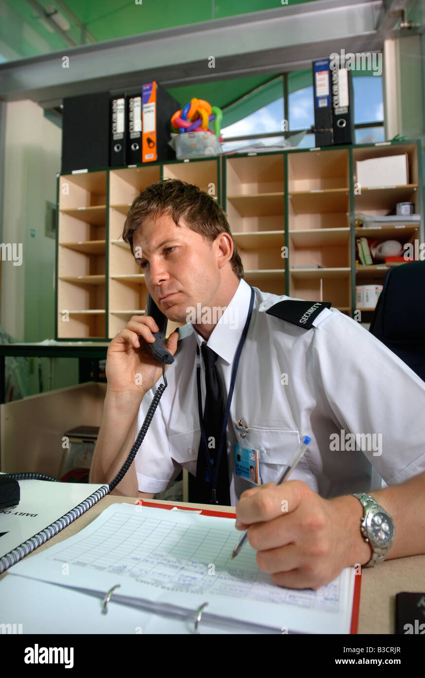 A SECURITY GUARD ANSWERS A PHONECALL AND MAKES AN ENTRY IN A LOG BOOK UK Stock Photo Alamy A SECURITY GUARD ANSWERS A PHONECALL AND MAKES AN ENTRY IN A LOG BOOK UK Stock Photo Alamy
