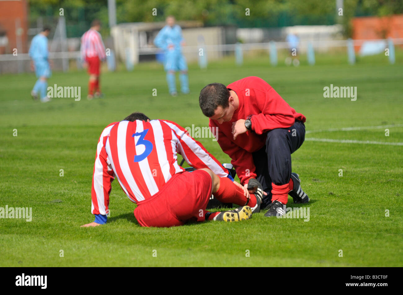 football player receives attention for ankle injury Stock Photo Alamy