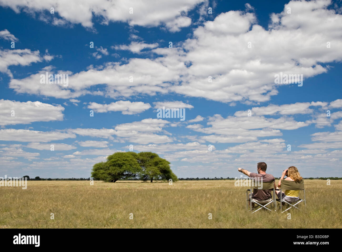 Africa, Botswana, Tourists looking at the landscape Stock Photo