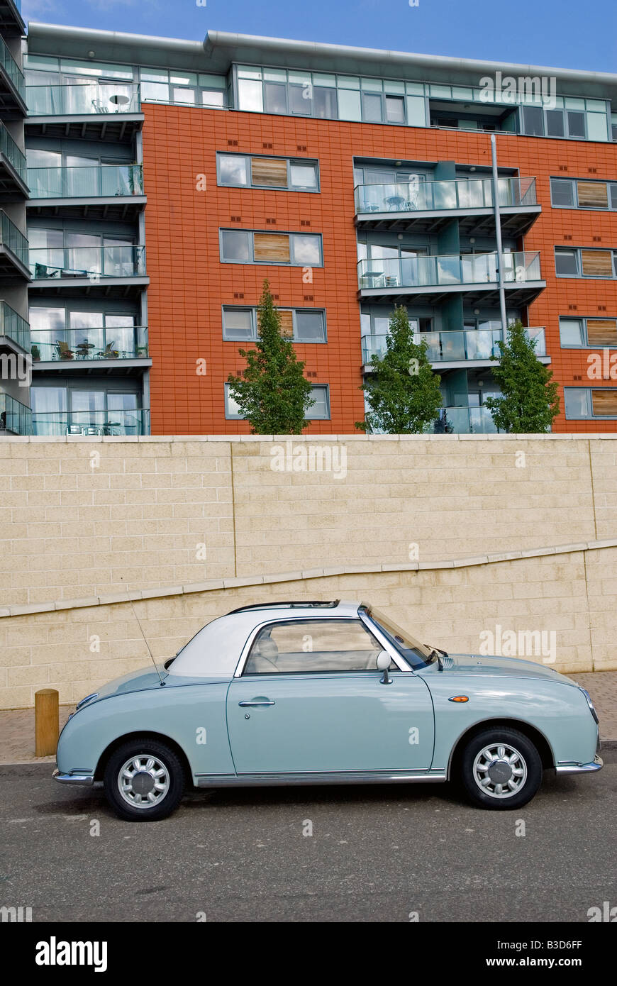 A Nissan Figaro retro car outside newly built apartments at Neptune Quay, Ipswich, Suffolk, UK. Stock Photo