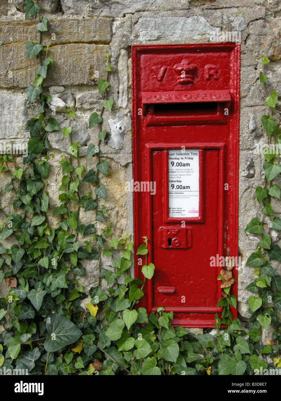 Old Victorian red painted post box in a wall in Dorset UK Stock Photo