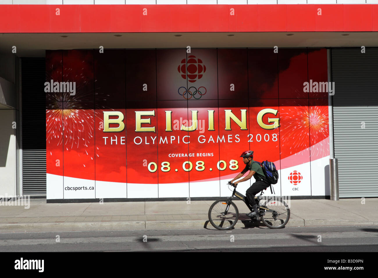 Cyclist passing by Canadian Broadcasting Company in Toronto Canada Stock Photo