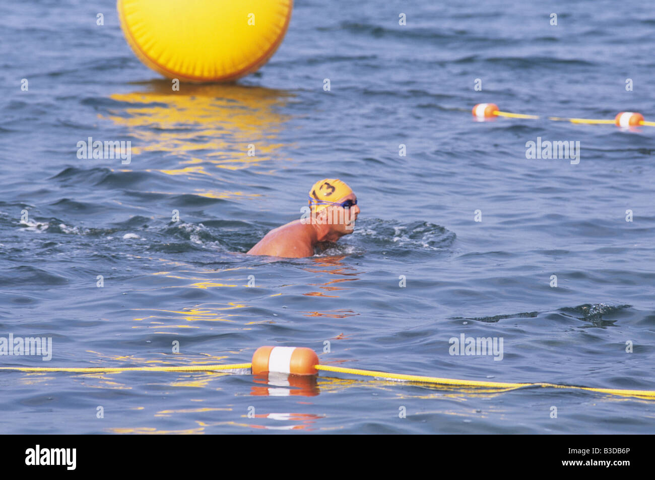 1 one man in swimming meet race with goggles and yellow swim cap with
