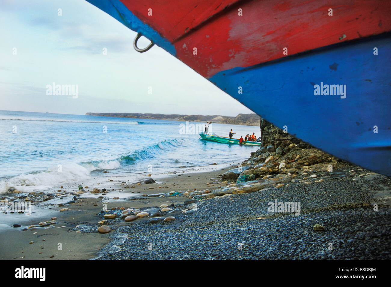 Fisherman load boat onto clean beach in San Mateo a small fishing village near Manta, ecuador on the pacific ocean. Stock Photo